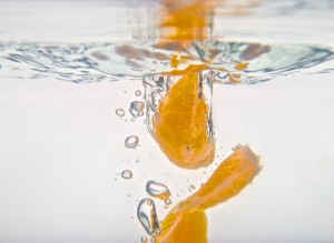 Orange wedges dropping into water